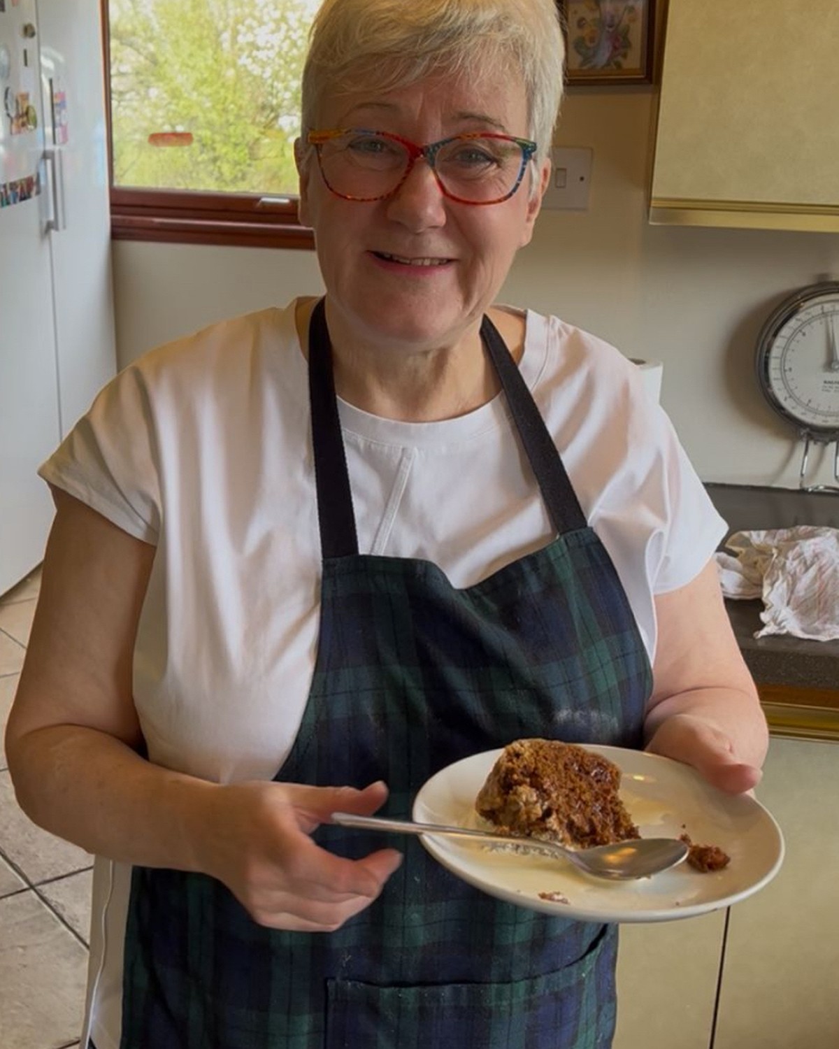 Tan in her kitchen holding a slice of cake